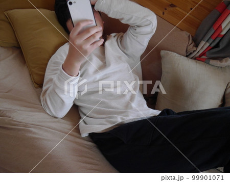 寝ながらスマホを見る子ども 寝ながらスマホを見る子ども 99901071