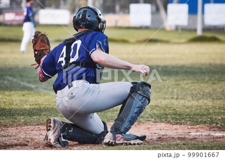 A baseball catcher holding up a leather glove on one knee on the pitch 99901667
