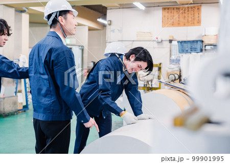 印刷工場でロール紙の確認をする作業員 99901995