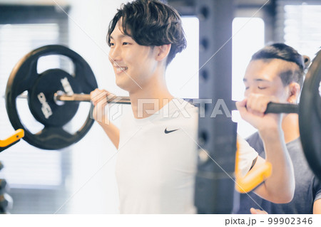 トレーナーとトレーニングに励む若い男性 トレーナーとトレーニングに励む若い男性 99902346