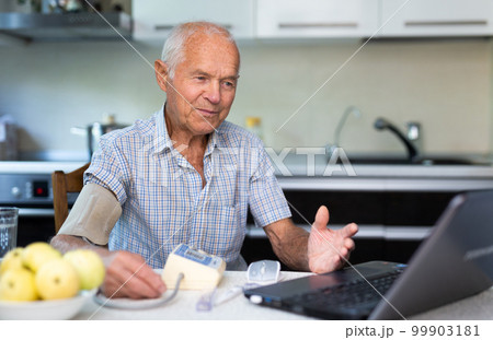 Man having video call with doctor, using laptop at home 99903181