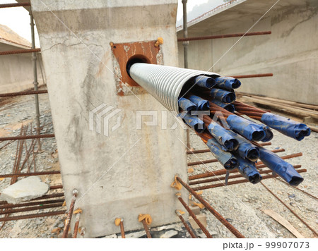 MELAKA, MALAYSIA -MAY 4, 2022: Pre-stress cable in the casing embedded in the concrete. It is part of the prestressed concrete. It is used to improve concrete slab quality with a larger span. MELAKA, MALAYSIA -MAY 4, 2022: Pre-stress cable in the casing embedded in the concrete. It is part of the prestressed concrete. It is used to improve concrete slab quality with a larger span. 99907073