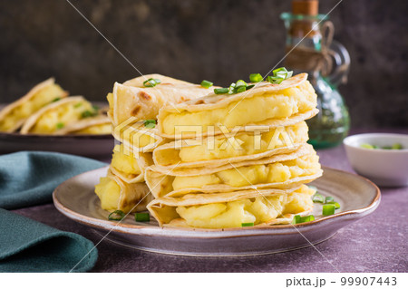 Kystyby - a thin flatbread filled with mashed potatoes and onions on a plate on the table. 99907443