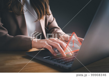 Businesswoman or programmer using computer laptop with triangle caution warning sign for notification error. Concept of computer virus detected, personal data protection, network security, maintenance Businesswoman or programmer using computer laptop with triangle caution warning sign for notification error. Concept of computer virus detected, personal data protection, network security, maintenance 99908346