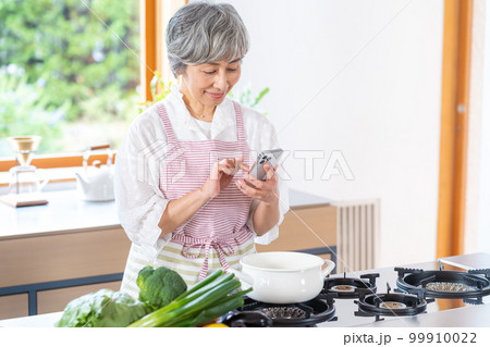 キッチンに立つ笑顔のシニア女性 99910022