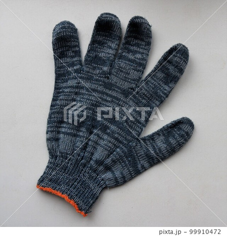 fabric glove made of gray-blue cotton material isolated on a light surface, one protective glove made of soft fabric lying on a plane close-up fabric glove made of gray-blue cotton material isolated on a light surface, one protective glove made of soft fabric lying on a plane close-up 99910472