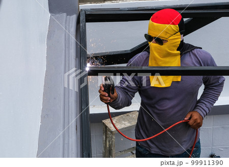 The welder is welding the steel structure to add to the house 99911390