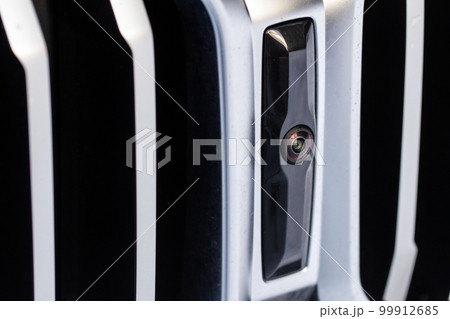 Close up view of front parking assist video camera on the car. Front view camera of modern car. Close up view of front parking assist video camera on the car. Front view camera of modern car. 99912685