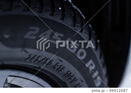 Close up view of snowy tire with tire width, height and wheel diameter designation. Close up view of snowy tire with tire width, height and wheel diameter designation. 99912687