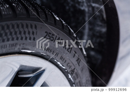 Close up view of snowy tire with tire width, height and wheel diameter designation.  99912696