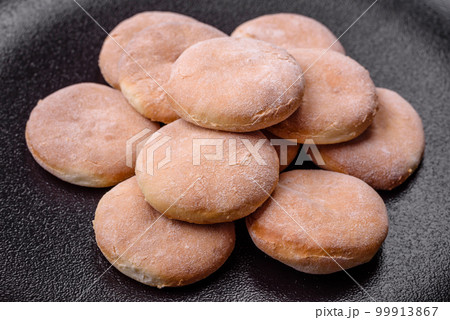 Delicious fresh baked cornmeal shortcakes or cookies on a black plate Delicious fresh baked cornmeal shortcakes or cookies on a black plate 99913867