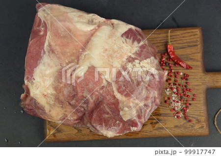 big piece of frosted mutton meat closeup photo on kitchen board 99917747