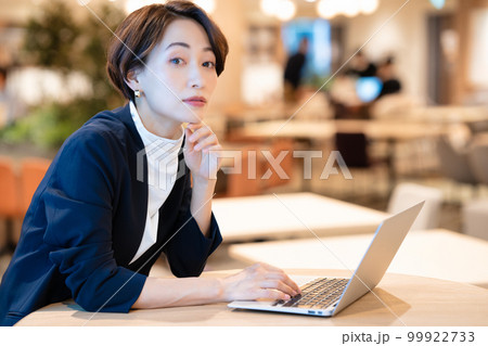 ノートパソコンを使うカフェの女性オーナー 99922733