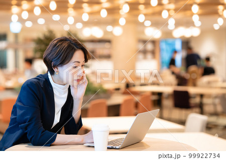 ノートパソコンを使うカフェの女性オーナー ノートパソコンを使うカフェの女性オーナー 99922734