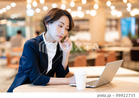 ノートパソコンを使うカフェの女性オーナー 99922735