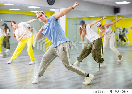 Teenage boy training breakdance Toprock moves in dance hall Teenage boy training breakdance Toprock moves in dance hall 99925063