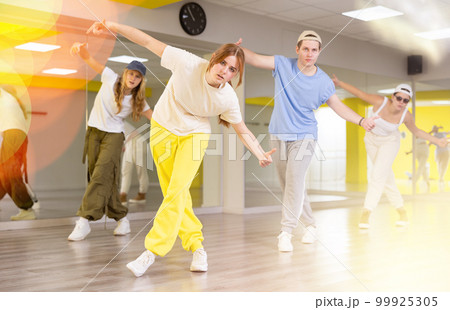 Teen girl dancing modern dances in dance studio Teen girl dancing modern dances in dance studio 99925305