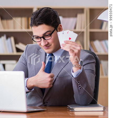 Businessman gambling playing cards at work Businessman gambling playing cards at work 99930471
