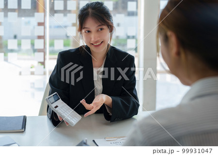 Guarantee, mortgage, contract, contract, signed, real estate agent or bank officer holding a calculator, submits a bid with a customer to buy a home before signing to make a deal. Guarantee, mortgage, contract, contract, signed, real estate agent or bank officer holding a calculator, submits a bid with a customer to buy a home before signing to make a deal. 99931047