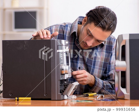 Young engineer repairing musical hi-fi system Young engineer repairing musical hi-fi system 99931656