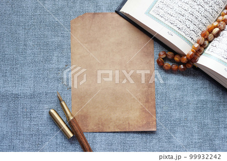 Holy book Quran and a empty paper on table  99932242