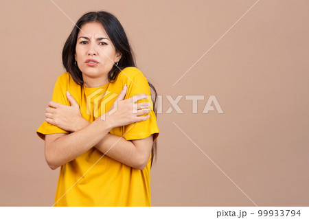 Woman looking at camera woman gesturing she is cold 99933794