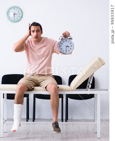 Young injured man waiting for his turn in hospital hall Young injured man waiting for his turn in hospital hall 99933917