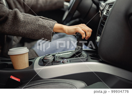 Close up of woman change speed holding hand on gearbox in the car 99934776