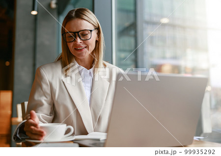 Successful businesswoman having coffee break time during working day in cafe. Distance work concept 99935292