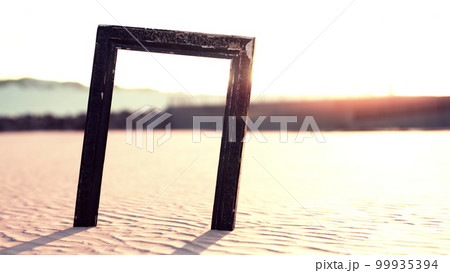 Empty wooden picture frame on the beach sand Empty wooden picture frame on the beach sand 99935394