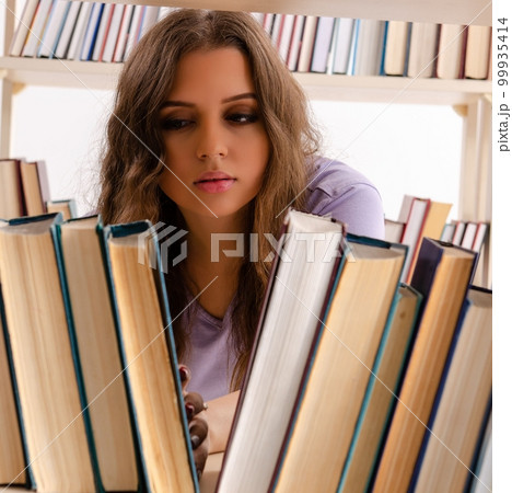 Young female student preparing for exams at library Young female student preparing for exams at library 99935414