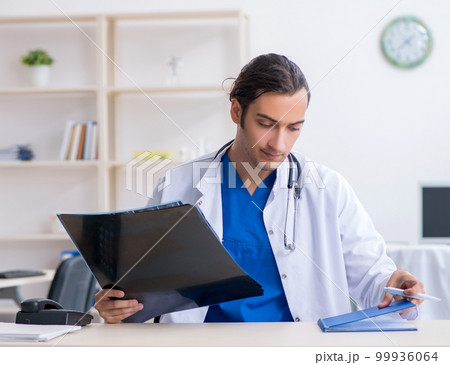 Young male doctor working in the clinic Young male doctor working in the clinic 99936064