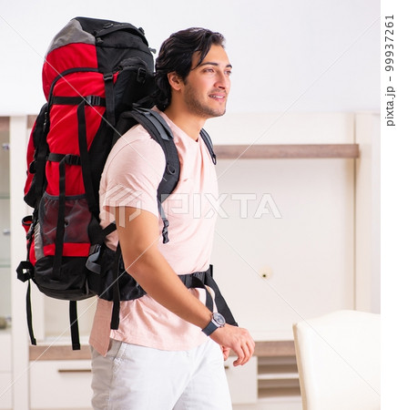 Young male tourist preparing for trip at home 99937261