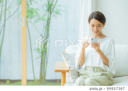 リビングの女性　スマホ　　　　 99937367
