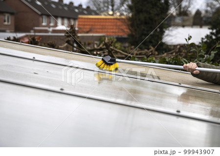 Washing the patio pergola roof cover made of aluminum. removing the dirty algae with brush soap and water close up in garden from a house terrace Washing the patio pergola roof cover made of aluminum. removing the dirty algae with brush soap and water close up in garden from a house terrace 99943907