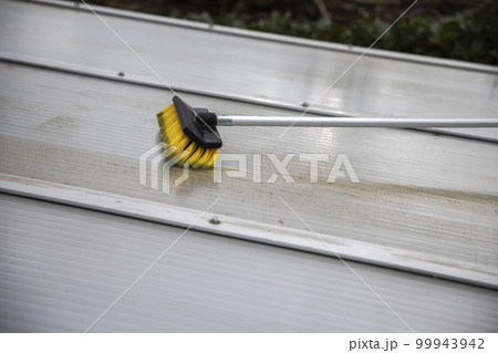 Washing the patio pergola roof cover made of aluminum. removing the dirty algae with brush soap and water close up in garden from a house terrace Washing the patio pergola roof cover made of aluminum. removing the dirty algae with brush soap and water close up in garden from a house terrace 99943942