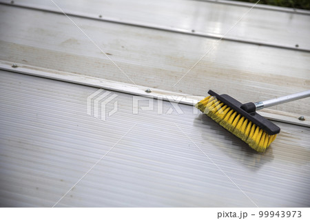 Washing the patio pergola roof cover made of aluminum. removing the dirty algae with brush soap and water close up in garden from a house terrace Washing the patio pergola roof cover made of aluminum. removing the dirty algae with brush soap and water close up in garden from a house terrace 99943973