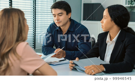 Young female asian candidate tries to impress interviewer by being competent. Young female asian candidate tries to impress interviewer by being competent. 99946545