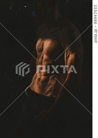 Shirtless man with sculpted body in the gym.  99947035