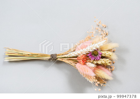 bouquet of dried flower and spikelets lies on gray bouquet of dried flower and spikelets lies on gray 99947378