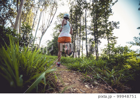 Woman trail runner running at tropical forest Woman trail runner running at tropical forest 99948751