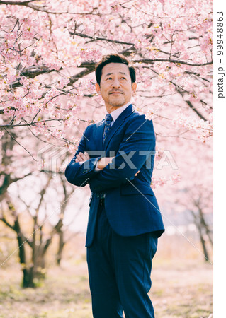 満開の桜とスーツを着たオジサン 99948863