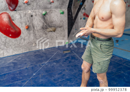 climbing magnesium on the hands of an athlete in a bouldering center 99952378