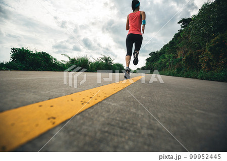 Fitness woman running on seaside trail in the morning 99952445