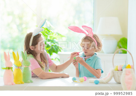 Kids on Easter egg hunt. Children dye eggs. 99952985