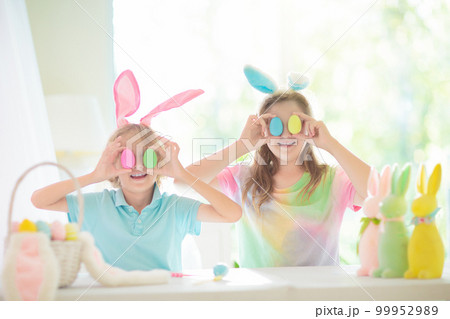 Kids on Easter egg hunt. Children dye eggs. 99952989