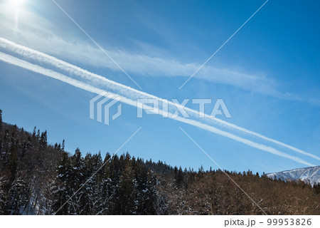 時間が経過し、やがて繋がった二本の飛行機雲【長野県】 99953826