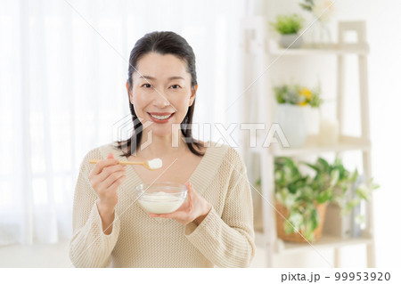 腸活　ヨーグルトを食べるミドルエイジの女性 99953920