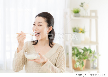 腸活　ヨーグルトを食べるミドルエイジの女性 99953923