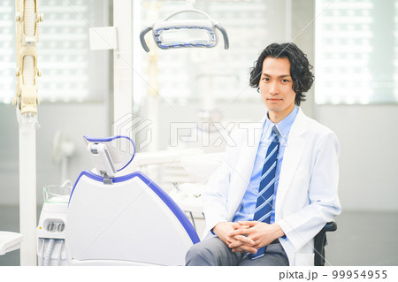 デンタルクリニックで働く若い男性歯科医師 99954955